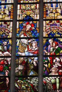 Stained glass depiction from St. Baavo Cathedral in Ghent of Jesus healing the sick. Photo by Thomas Quine.